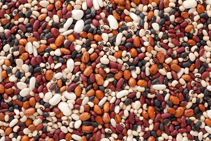 Top view of a variety of dried beans including kidney, black, black-eyed peas, lima, and pinto beans