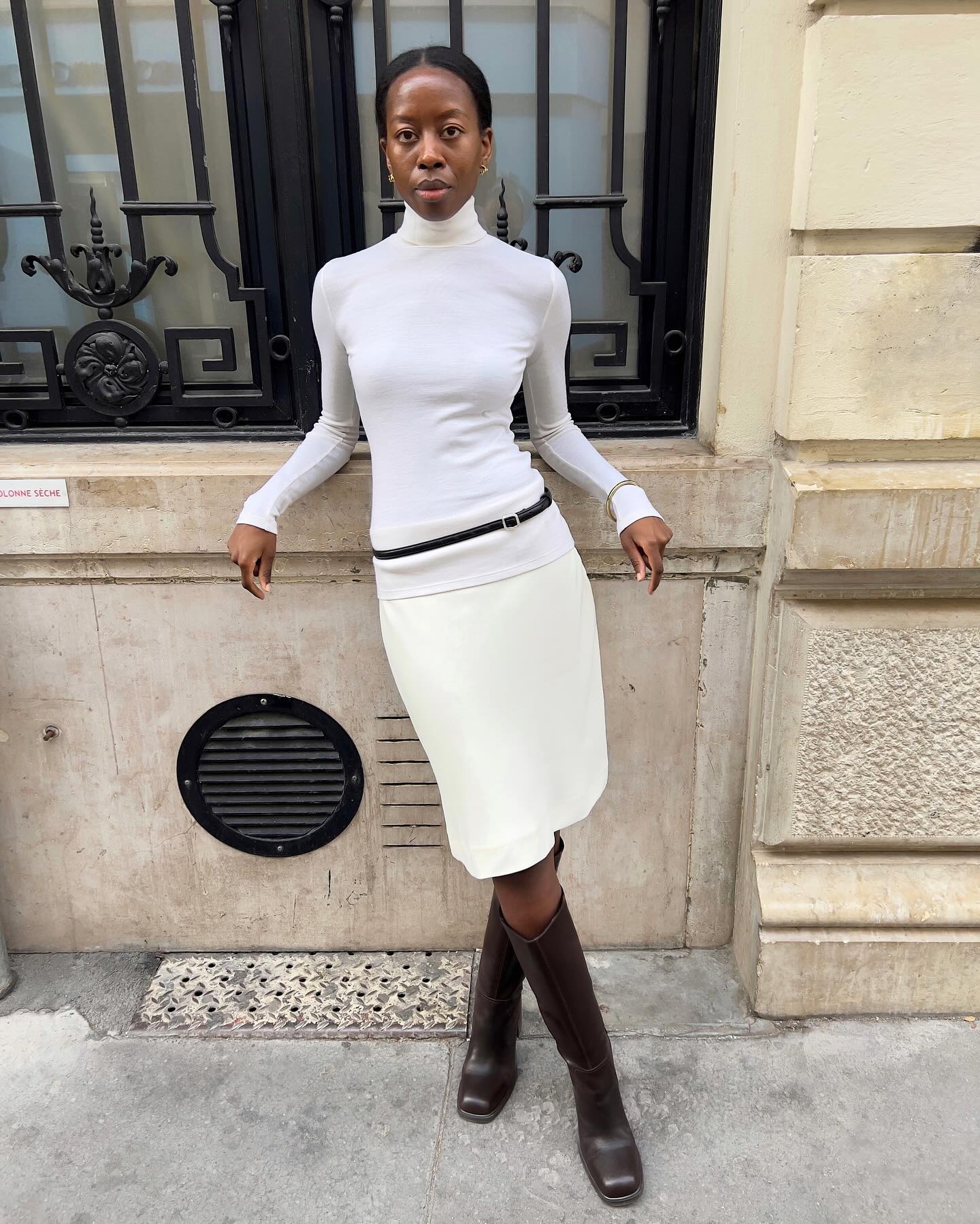 Woman in a white turtleneck and skirt