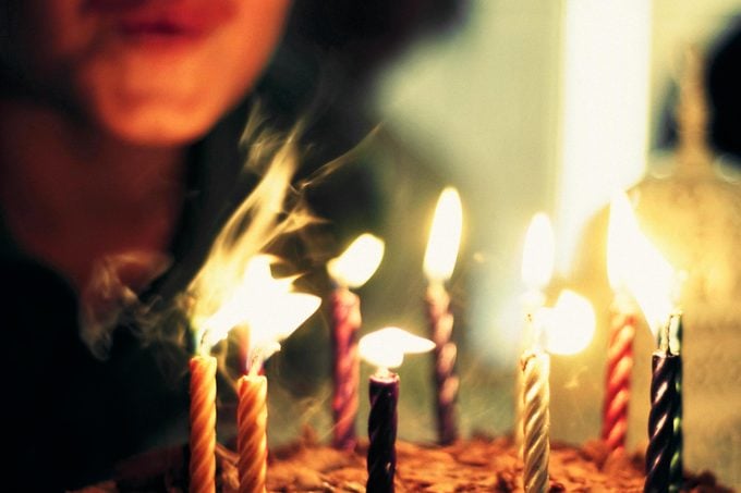 A person blowing out birthday candles