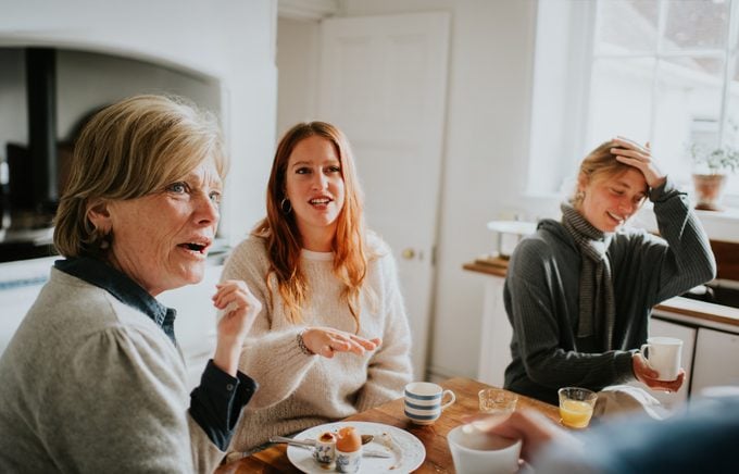 A family engaged in a heated discussion around a kitchen table