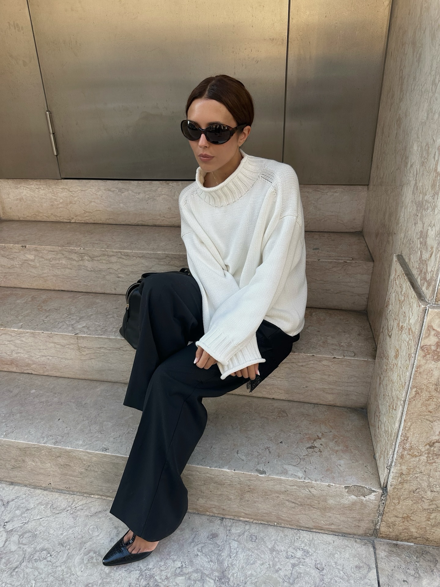 Woman in white sweater and black pants