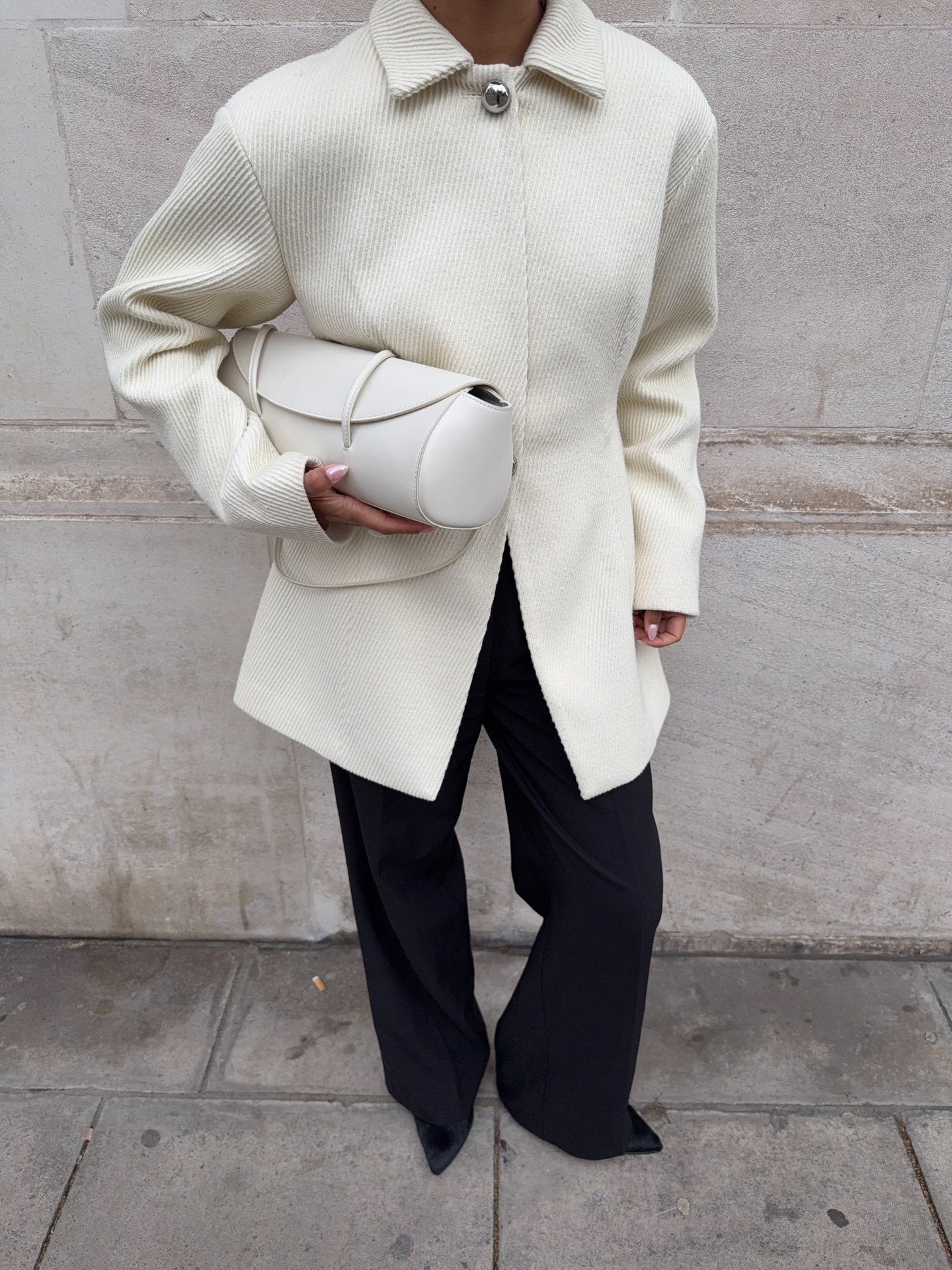 Woman in a white coat and black pants