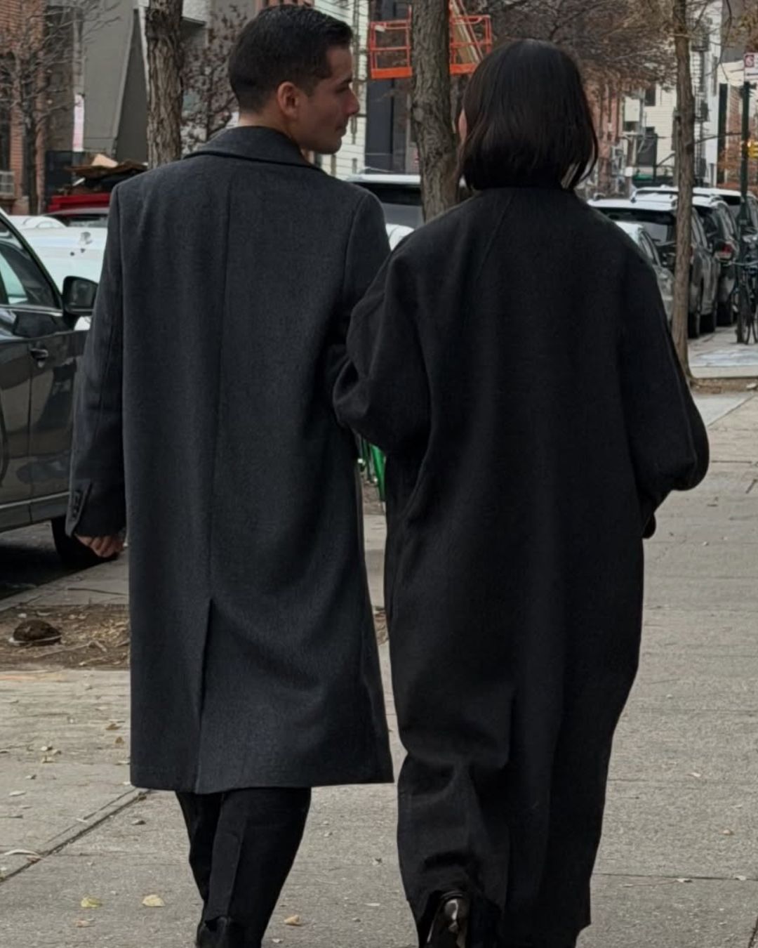 A picture of a couple walking down the street in New York City.
