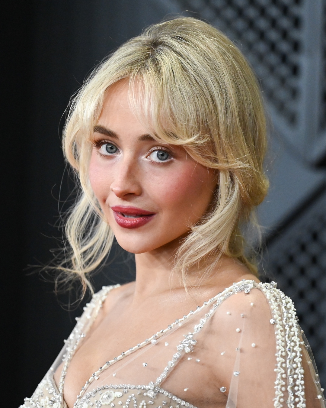 Sabrina Carpenter with ethereal eye makeup and berry-toned lips at 2026 Grammy Awards.