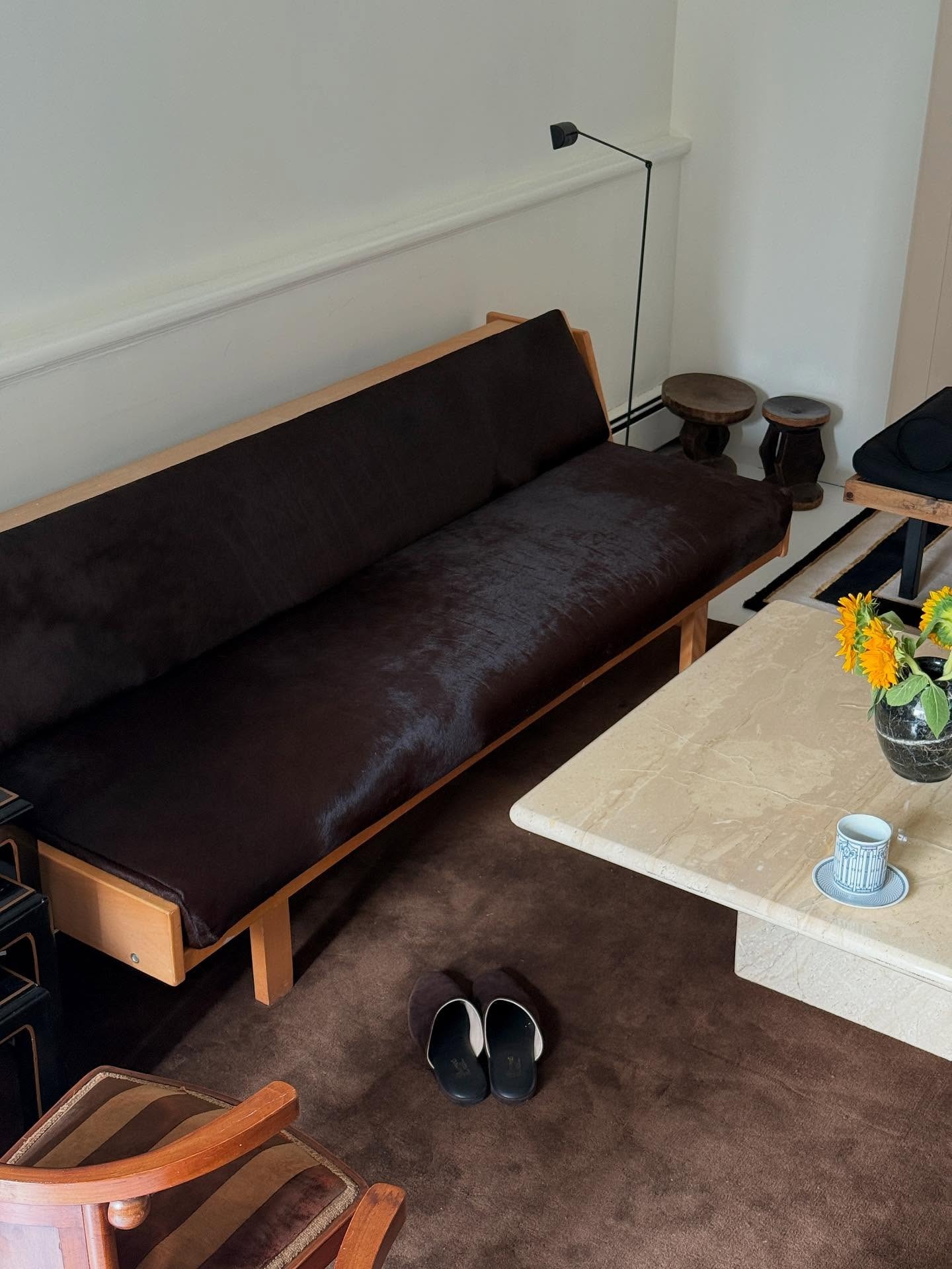 Christie Tyler's calf hair couch with a brown rug and brown Charvet slippers on the floor.