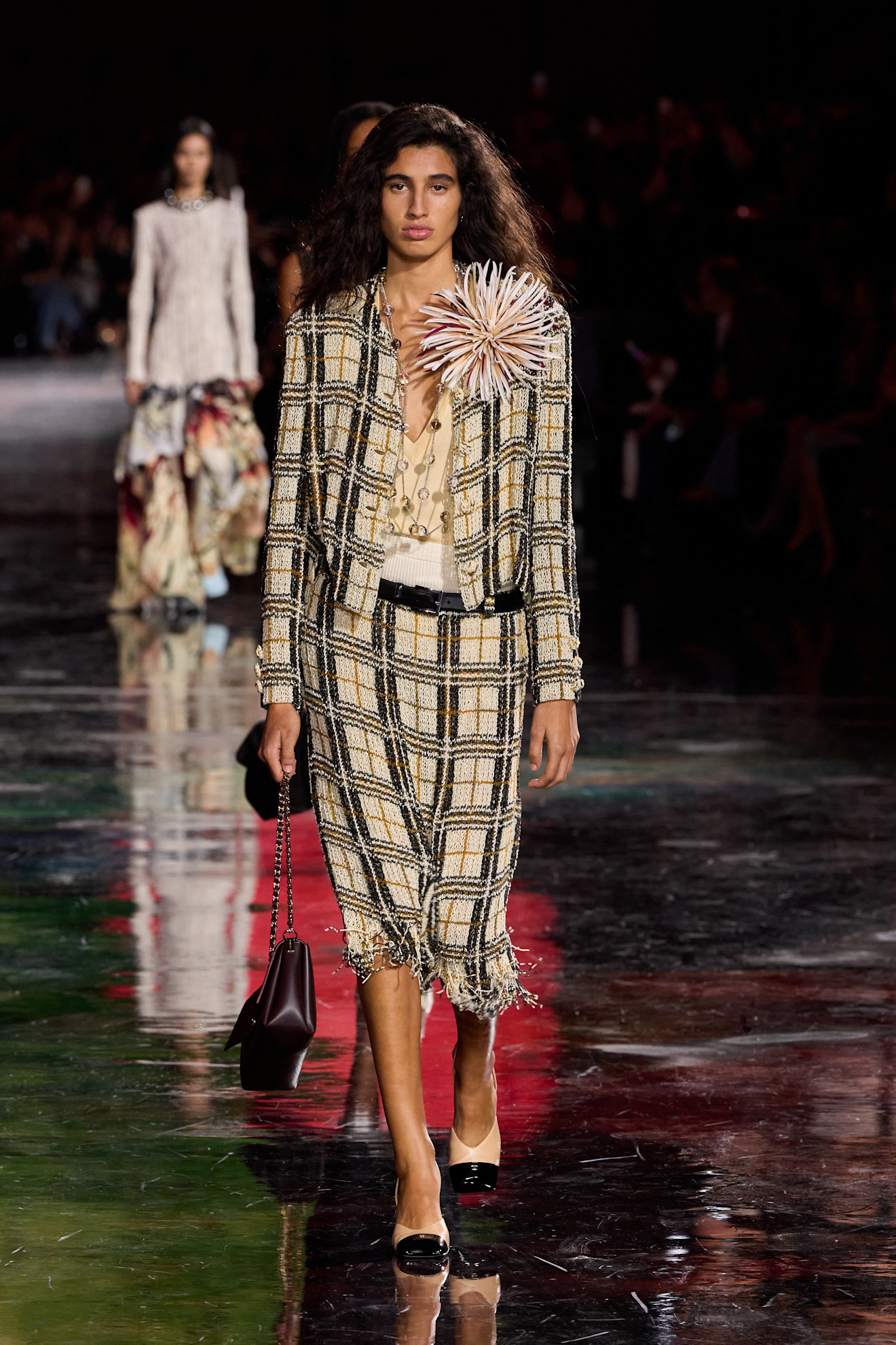 Woman in a tweed suit on the Chanel SS26 runway