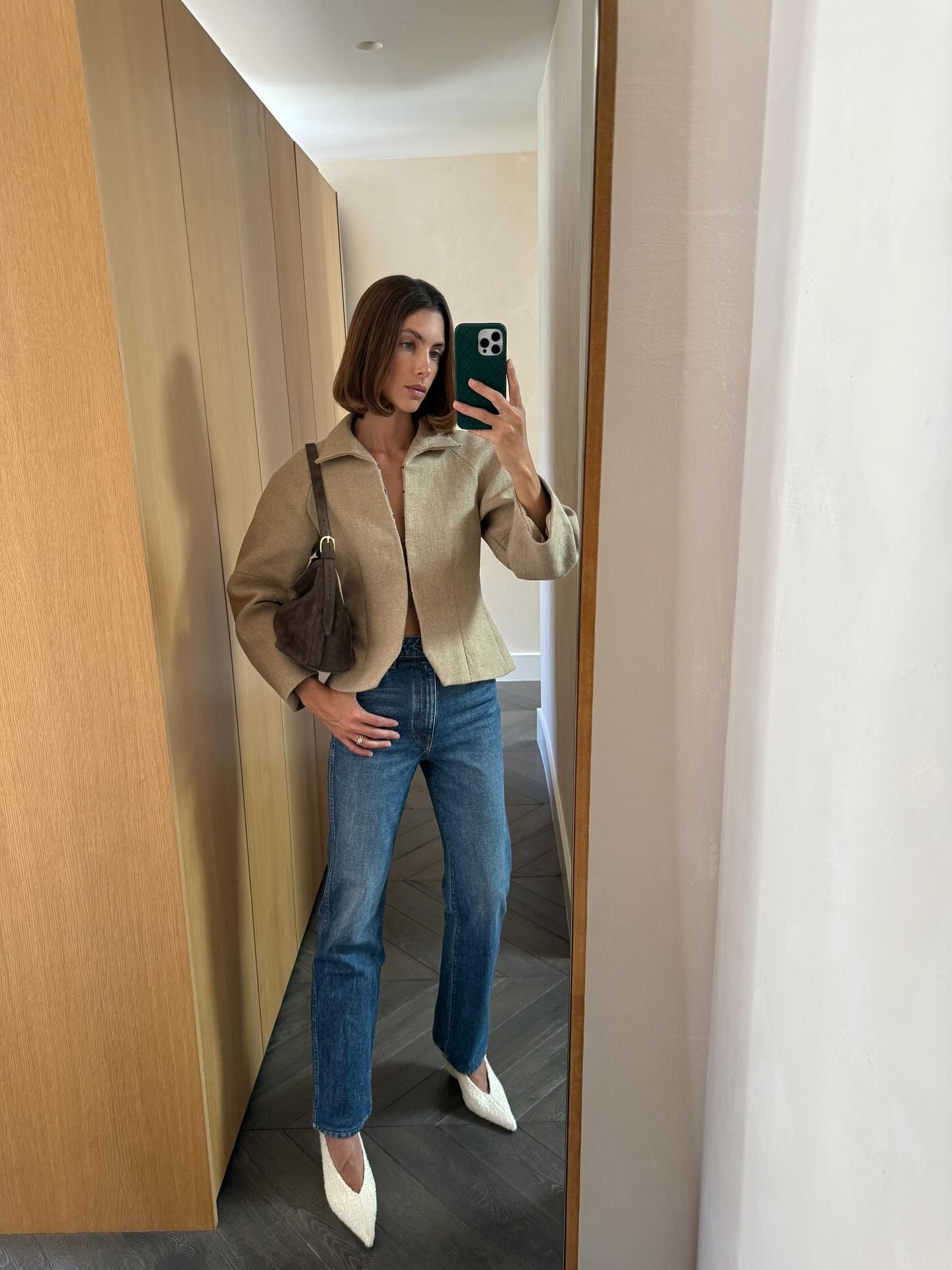 Woman in beige blazer and blue slim jeans