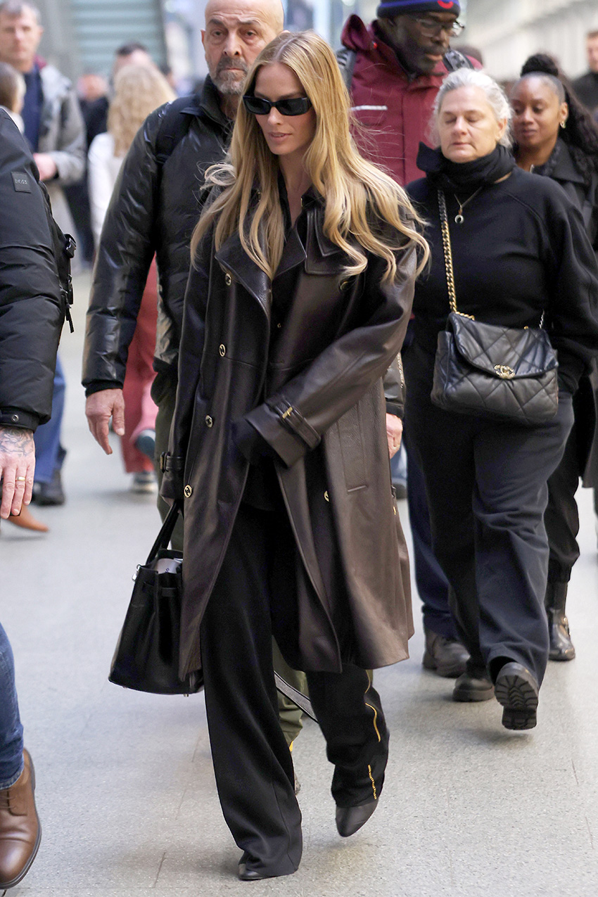 Margot Robbie wearing a Chanel leather trench and track pants at the Eurostar station in Paris