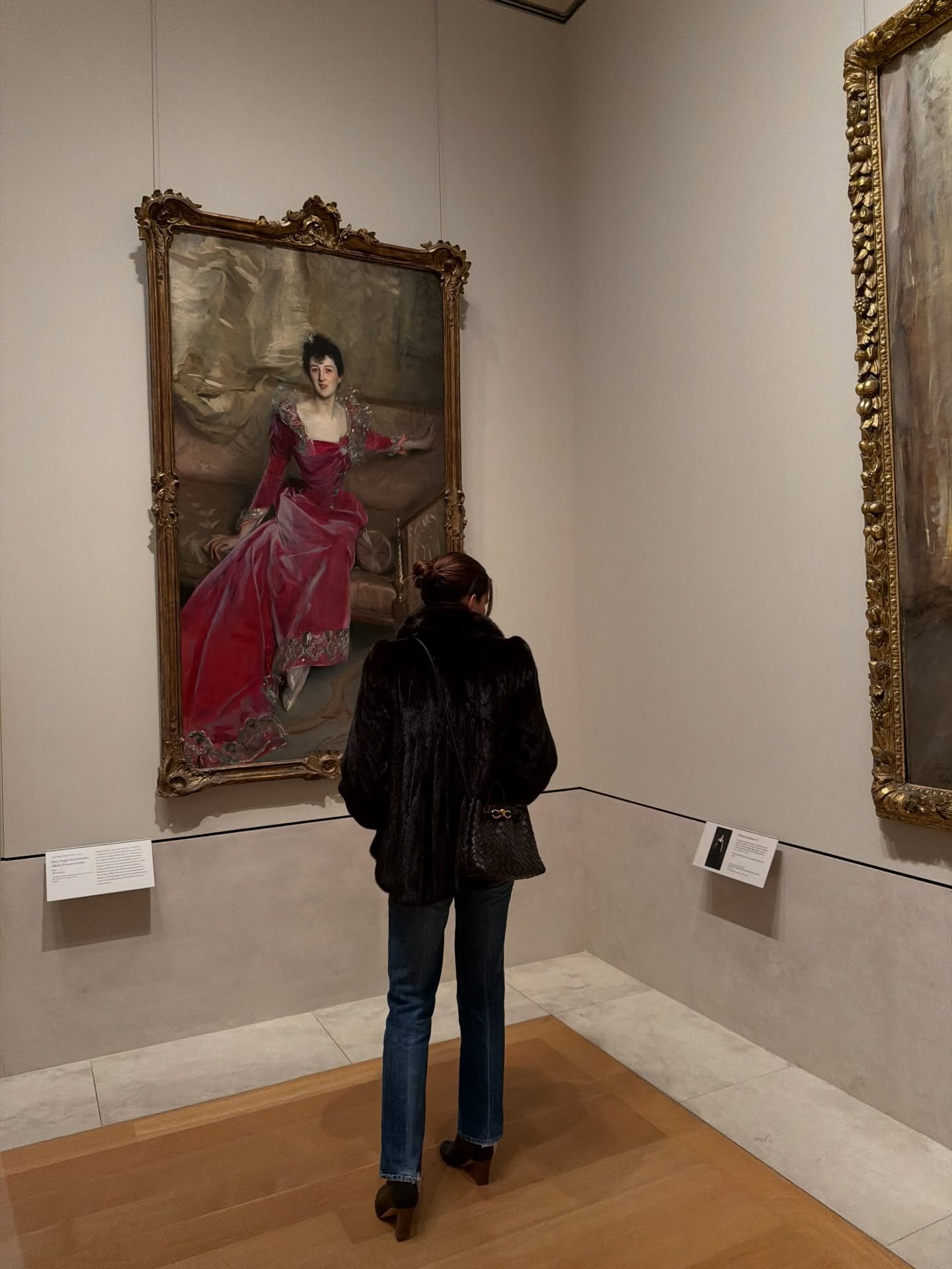 Eliza wears a fur coat, stovepipe jeans, and boots.